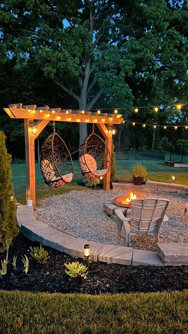 15 Acreage Garden Ideas for Large Land That Works 2 A stone fire pit with a glowing fire surrounded by chairs and a wooden pergola.