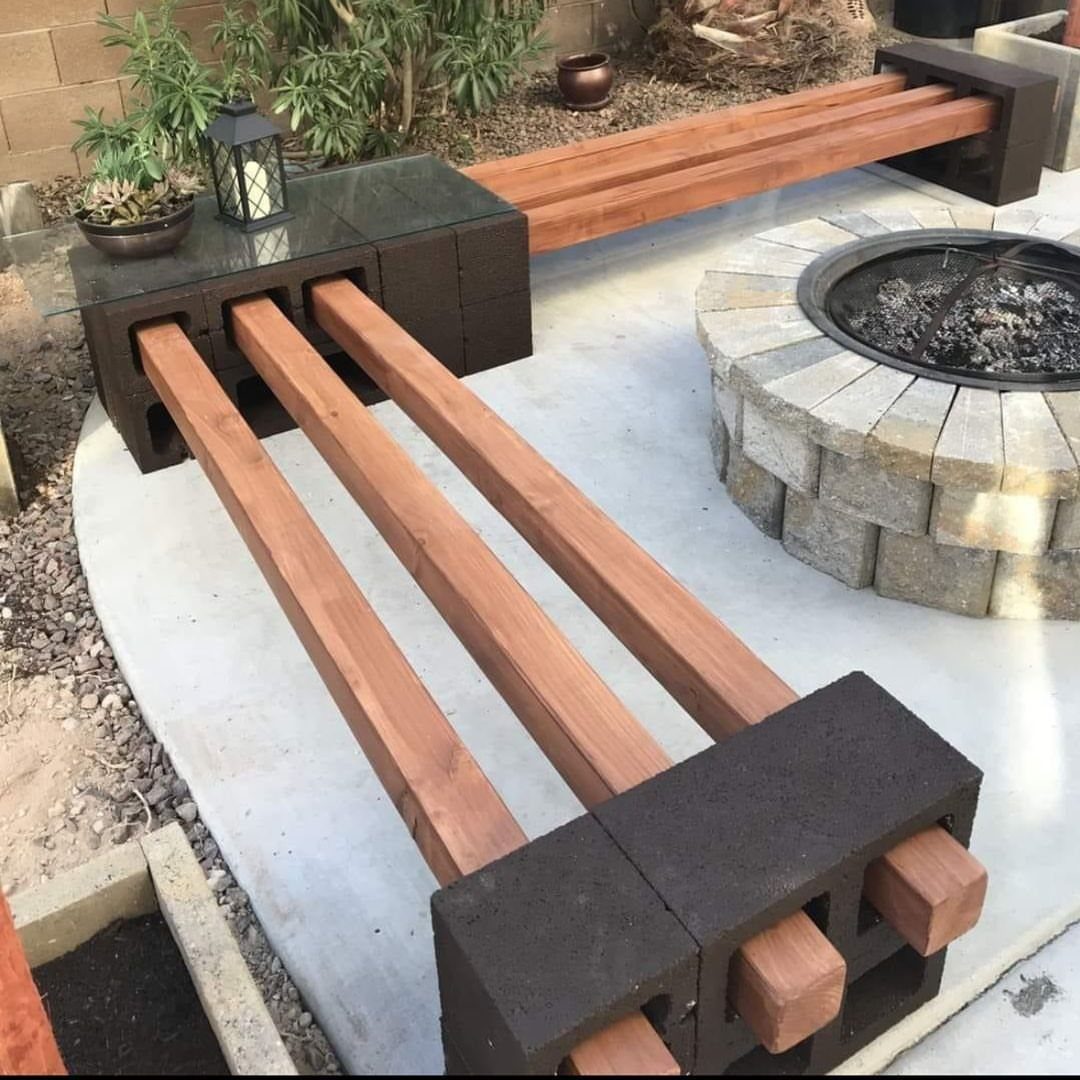 21 Back Garden Ideas from Potagers to Fire Pits 18 A DIY bench constructed from dark cinder blocks and wooden slats near a stone fire pit.