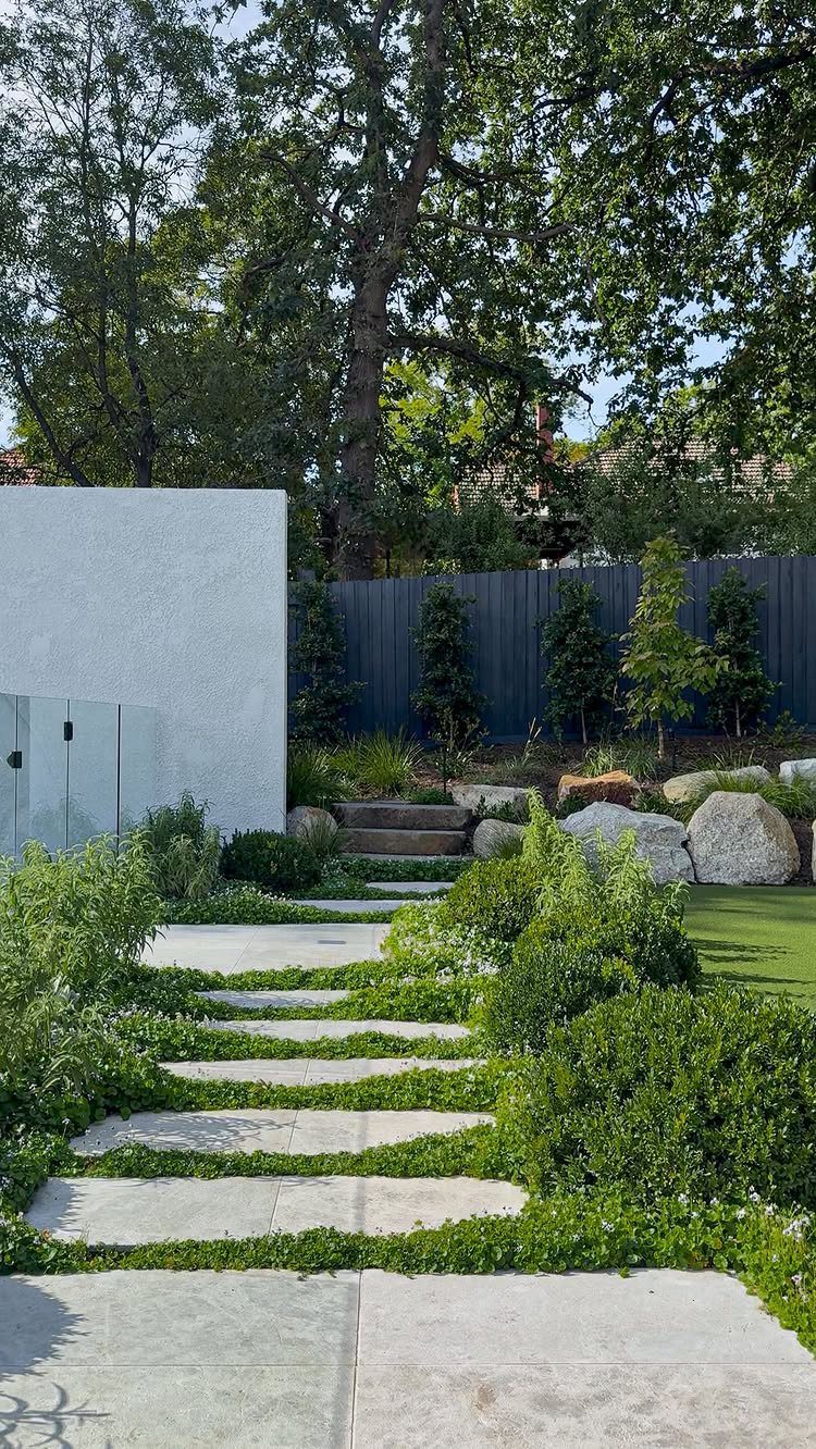 21 Back Garden Ideas from Potagers to Fire Pits 10 Stone pavers embedded in thick green ground cover plants forming a garden pathway.