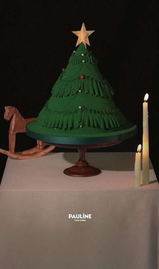 12 Beautiful Christmas Cake Ideas That Rival Bakery Work 5 A green frosted cake shaped like a Christmas tree with a gold star topper.