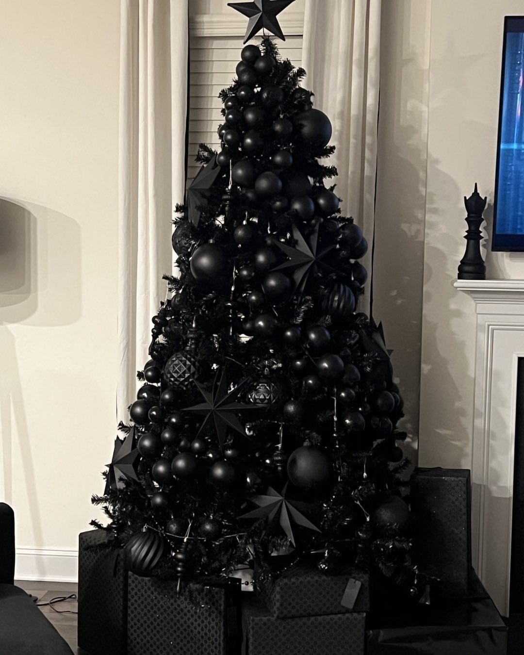 14 Beautiful Christmas Tree Decorations and How to Style Them 5 A Christmas tree decorated exclusively with various black ornaments and star shapes in a room.