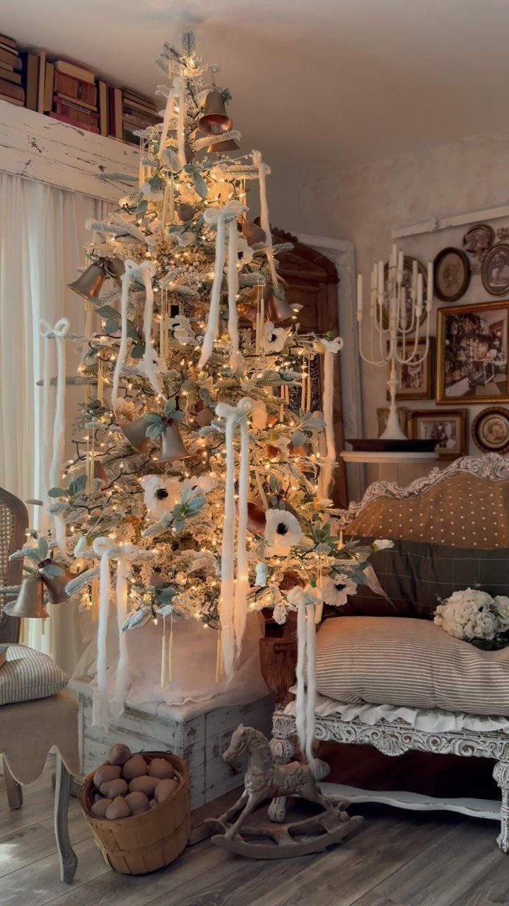 14 Beautiful Christmas Tree Decorations and How to Style Them 6 Decorated Christmas tree with white ribbons and warm lights in a vintage styled room.