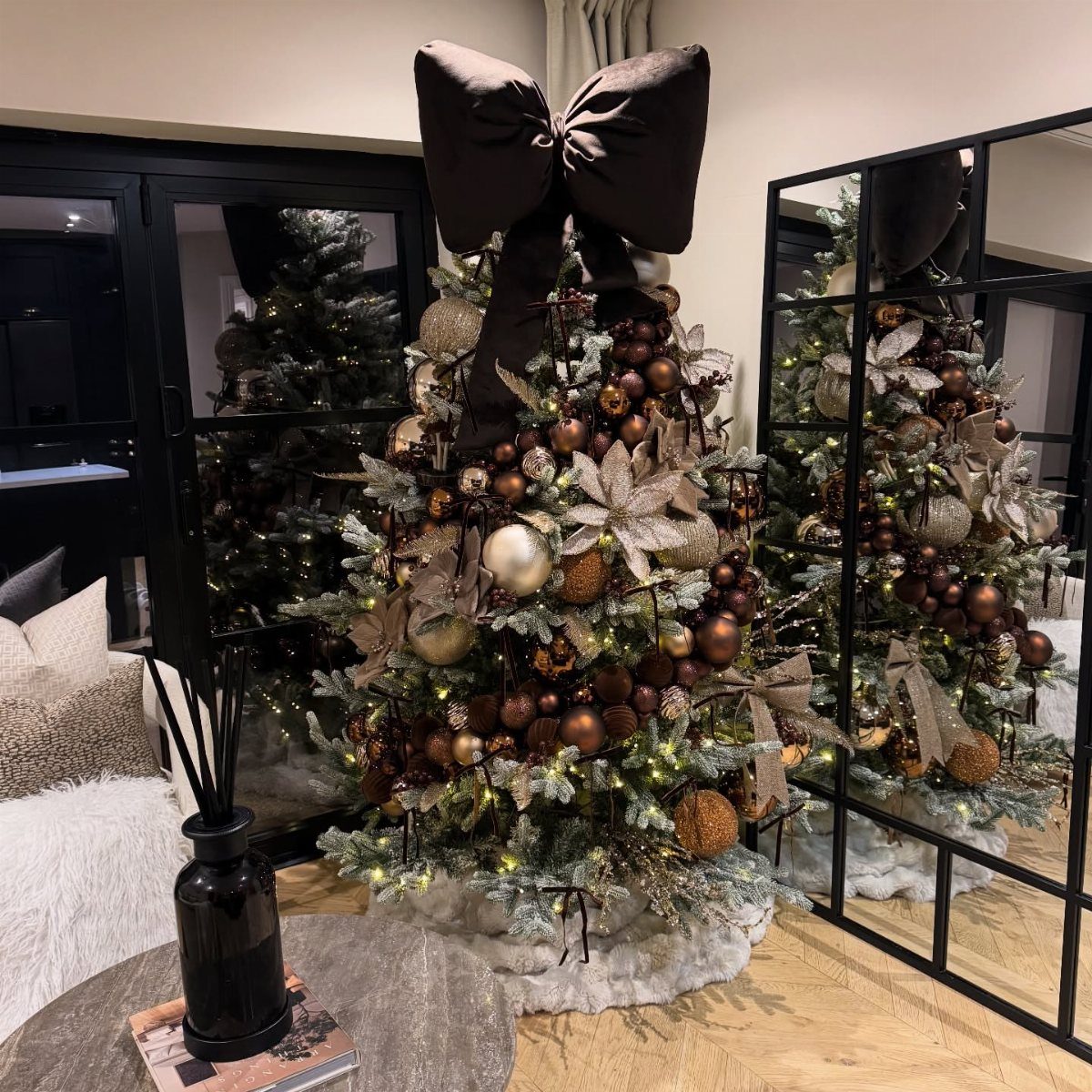 14 Beautiful Christmas Tree Decorations and How to Style Them 14 Decorated Christmas tree with bronze ornaments, large flowers, and a giant dark brown bow on top.