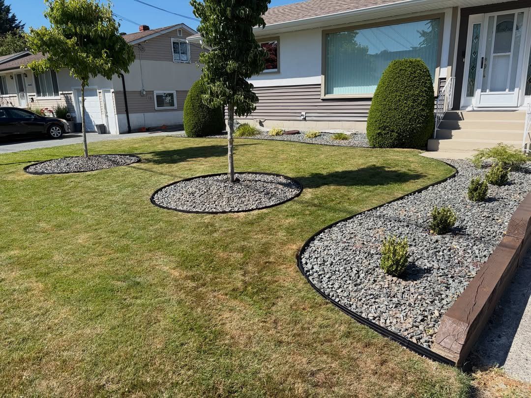 17 Cheap Yard Ideas for a Better Front or Back Garden 6 Grey gravel landscaping beds with small shrubs and black edging in a residential front yard.