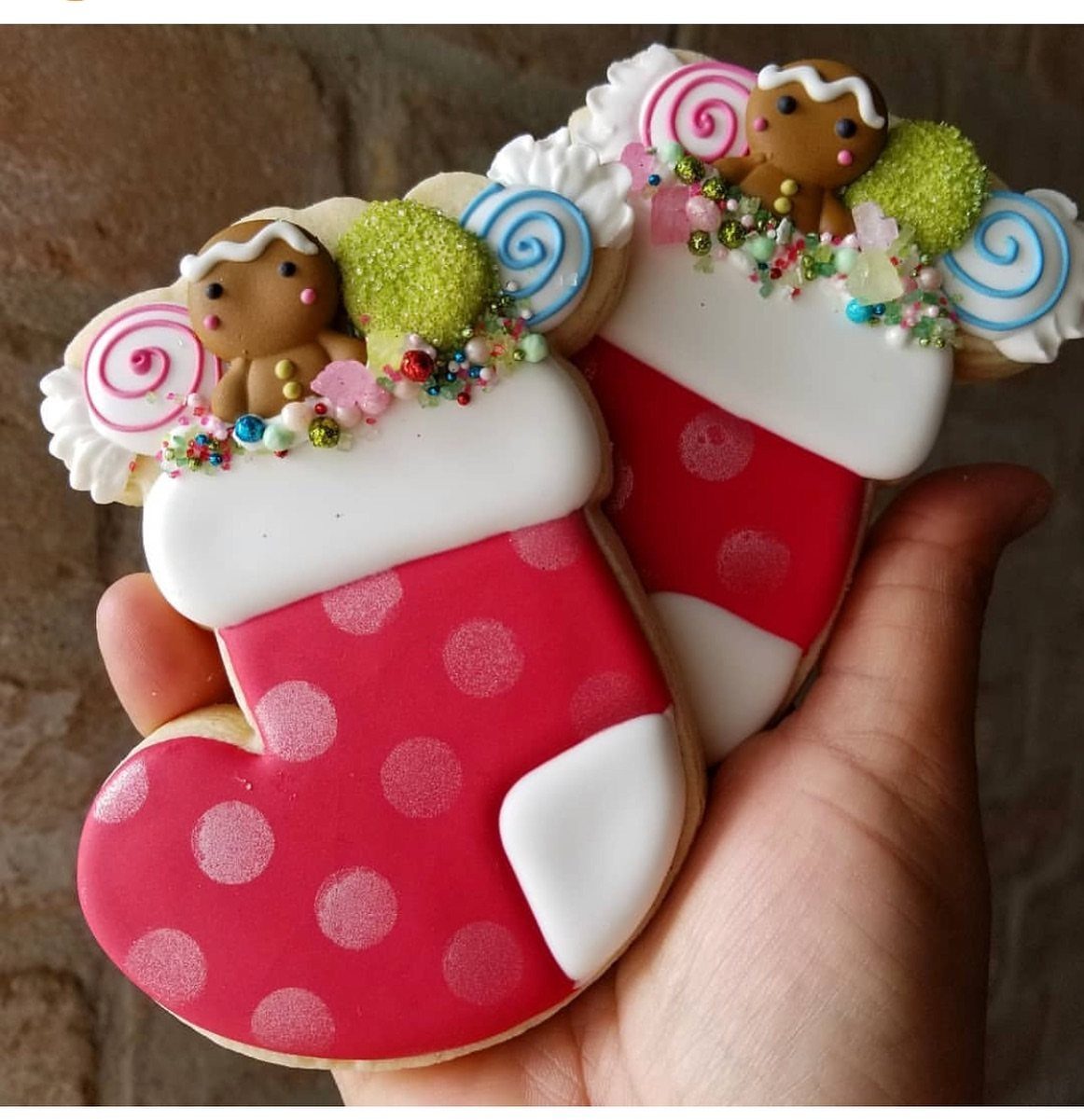 13 Christmas Cookie Decorations Ideas for Your Holiday Baking 8 Two red and white polka dot stocking cookies decorated with gingerbread men and sprinkles held in a hand.