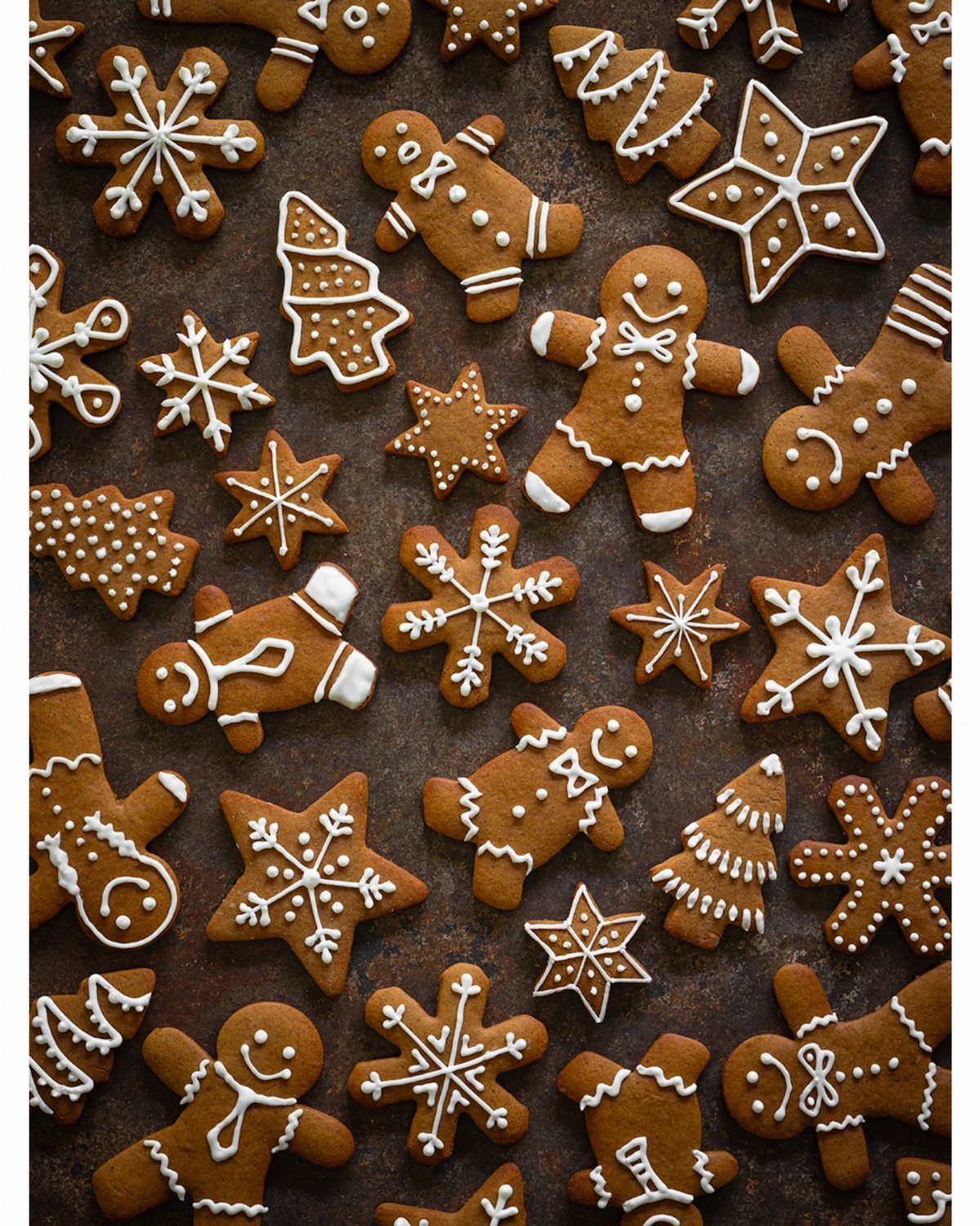 13 Christmas Cookie Decorations Ideas for Your Holiday Baking 6 Gingerbread cookies shaped like stars, snowflakes, and gingerbread men decorated with white icing.