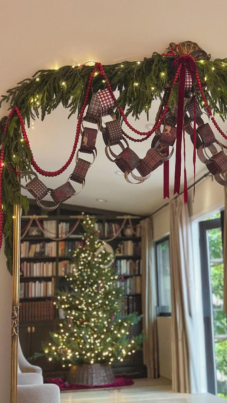 Christmas Craft for Adults: 5 Projects That Belong to the Evening 2 Paper chain garland with red beads and pine branches hanging over a doorway near a Christmas tree.