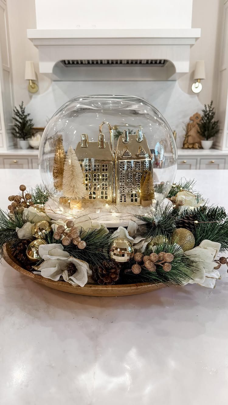 Christmas Craft for Adults: 5 Projects That Belong to the Evening 4 A glass cloche containing a miniature golden village scene surrounded by festive pine branches and ornaments.