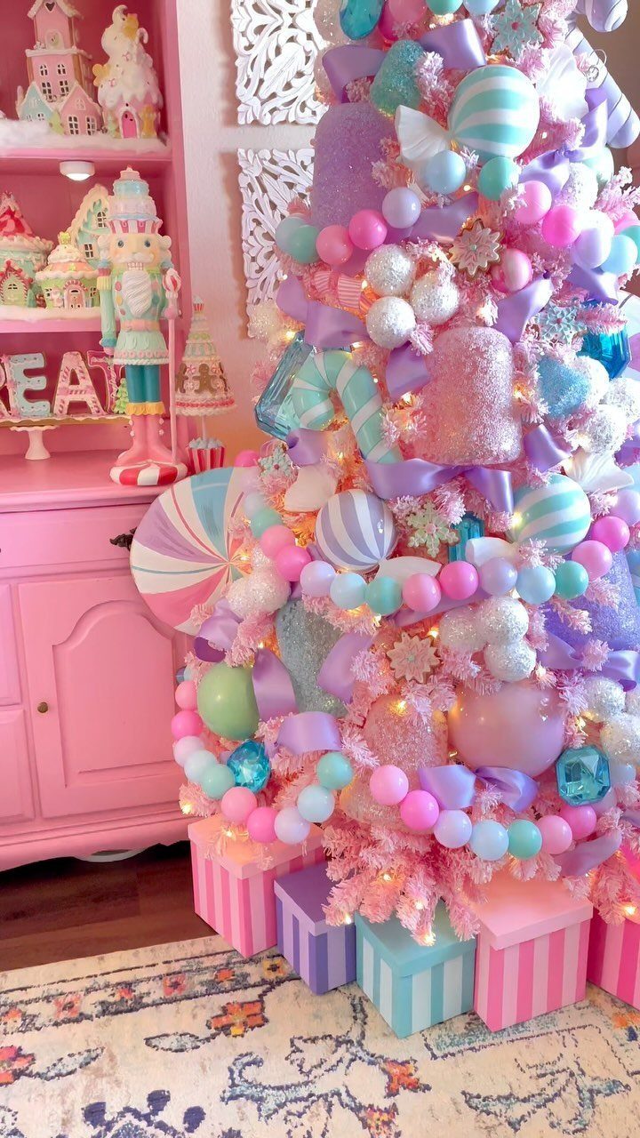 Christmas Decor Aesthetic: 13 Looks to Try This Season 2 A pink Christmas tree decorated with pastel blue, lavender, and mint ornaments and large bows.