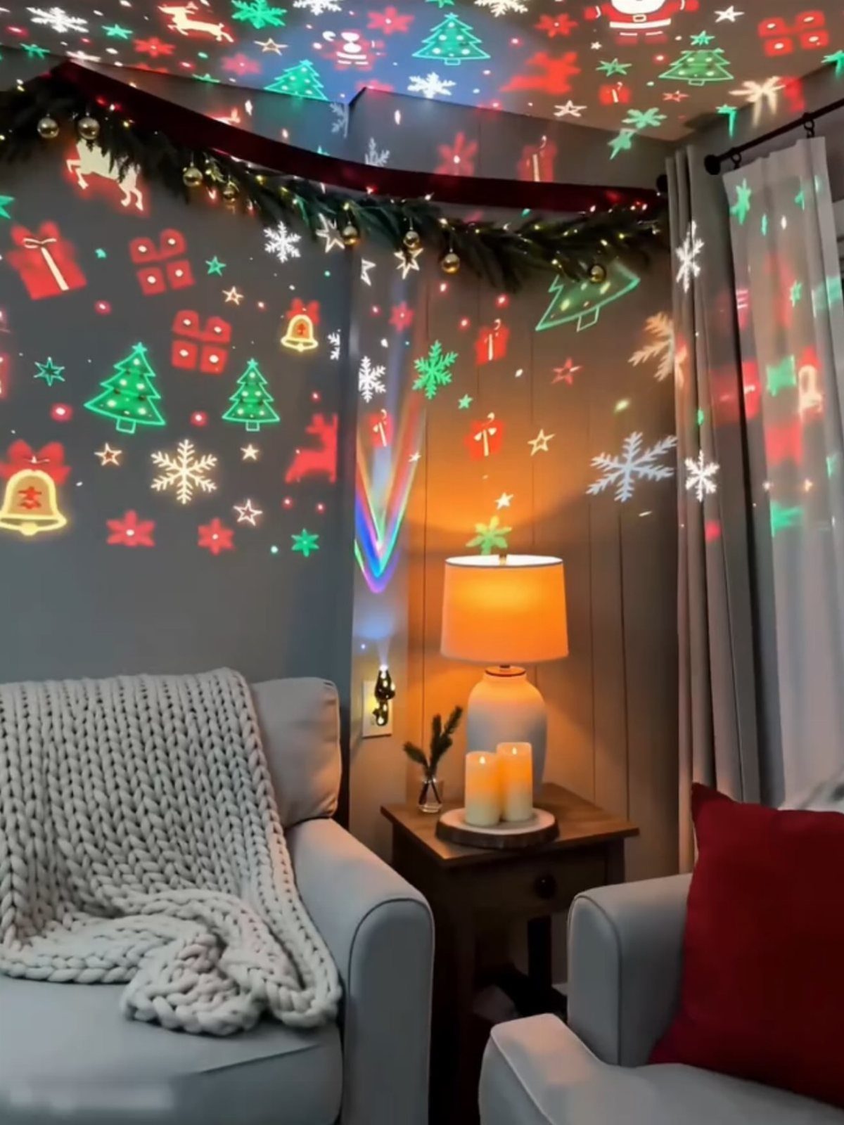 Christmas Decoration House: 6 Spaces to Dress, From Porch to Bedroom 5 Colorful Christmas light projections of trees and snowflakes decorating a cozy living room corner.