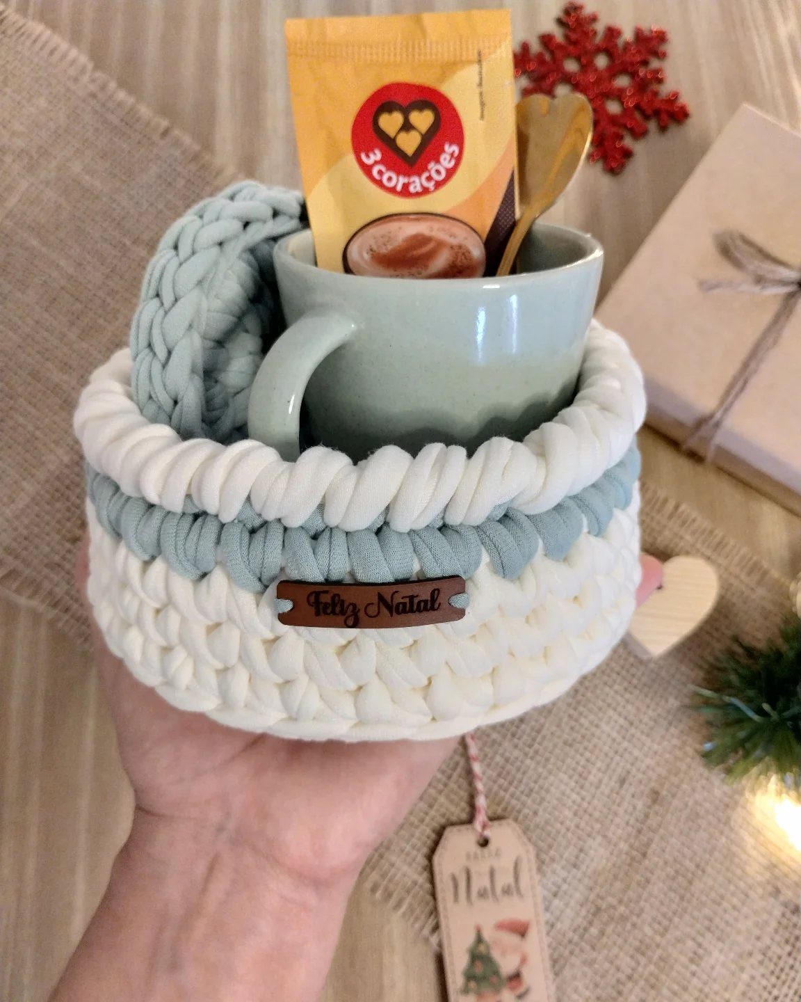 18 Christmas Gift Crochet Ideas for Everyone on Your List 8 A hand holding a small white and blue crochet basket containing a green mug.