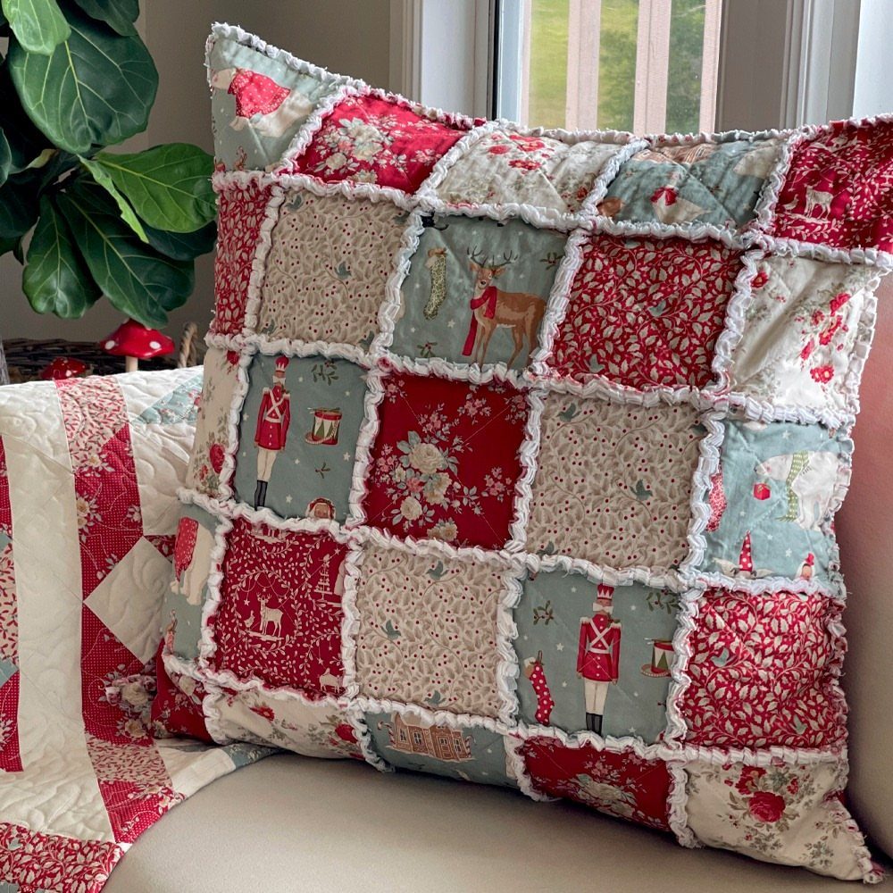16 Christmas Sewing Projects That Cover the Whole Holiday 4 A patchwork Christmas pillow with red and blue holiday patterns and white ruffled seams.