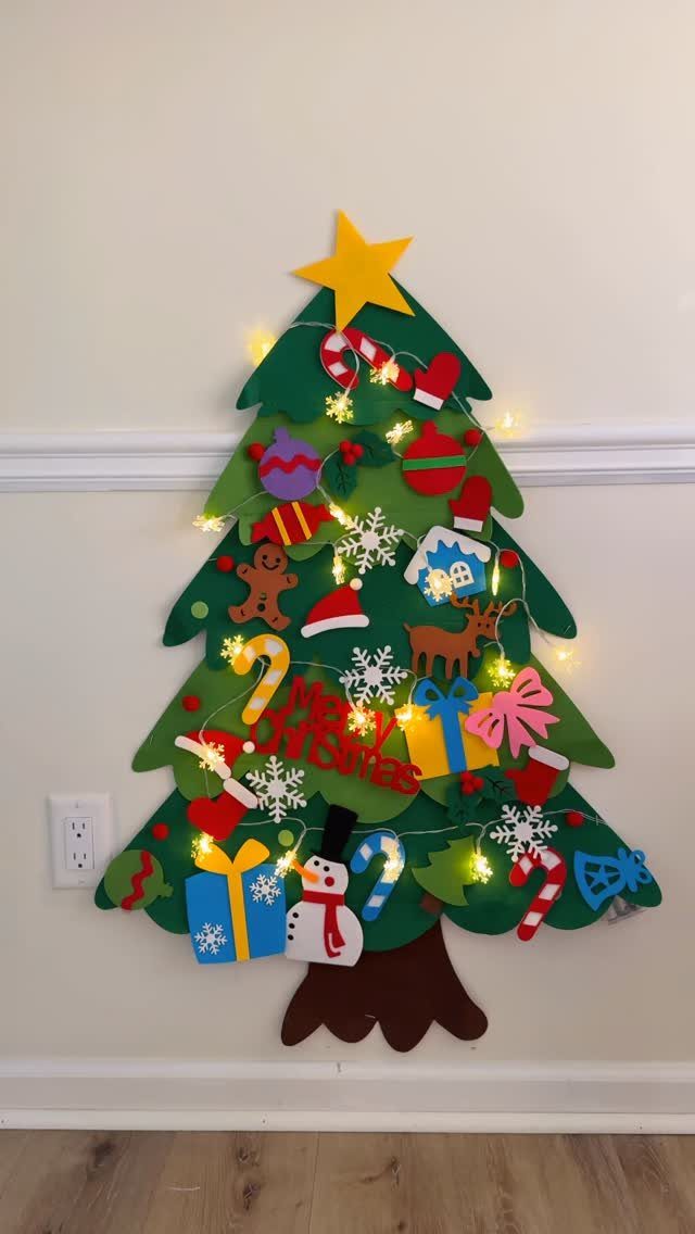 16 Christmas Sewing Projects That Cover the Whole Holiday 14 A green felt Christmas tree wall decoration decorated with colorful felt ornaments and small lights.