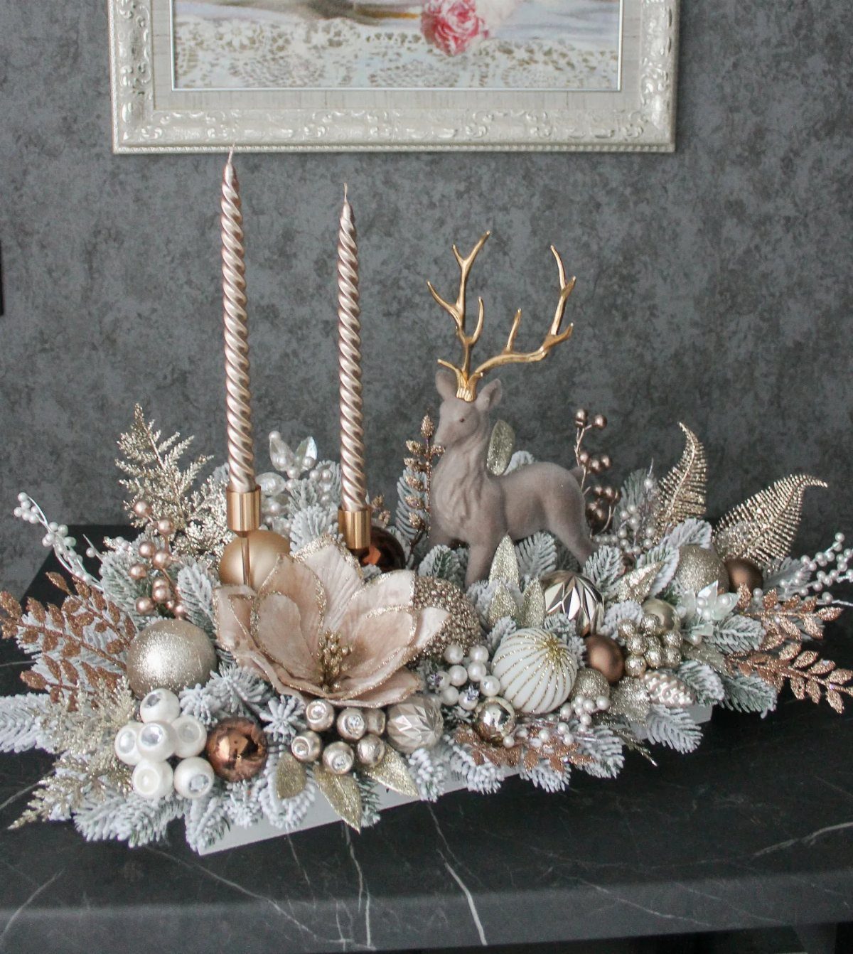 13 Christmas Table Decoration Ideas for Every Style 10 Festive centerpiece with gold candles, a deer figurine, and metallic ornaments on a dark surface.