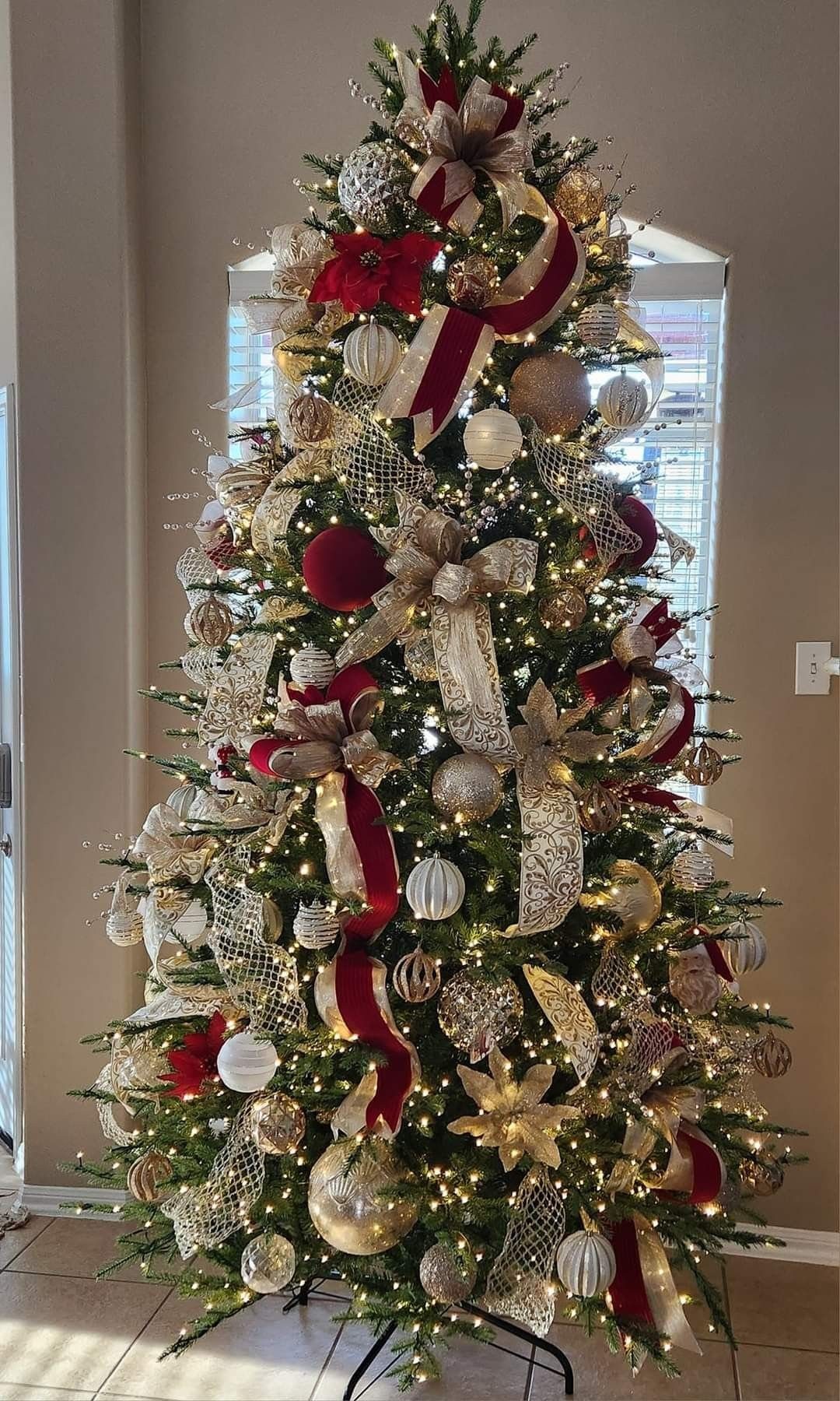 8 Christmas Tree Red and White Gold Decor Ideas for Holiday Elegance 4 Decorated Christmas tree with red velvet bows, gold ribbons, and white ornaments under warm lights.