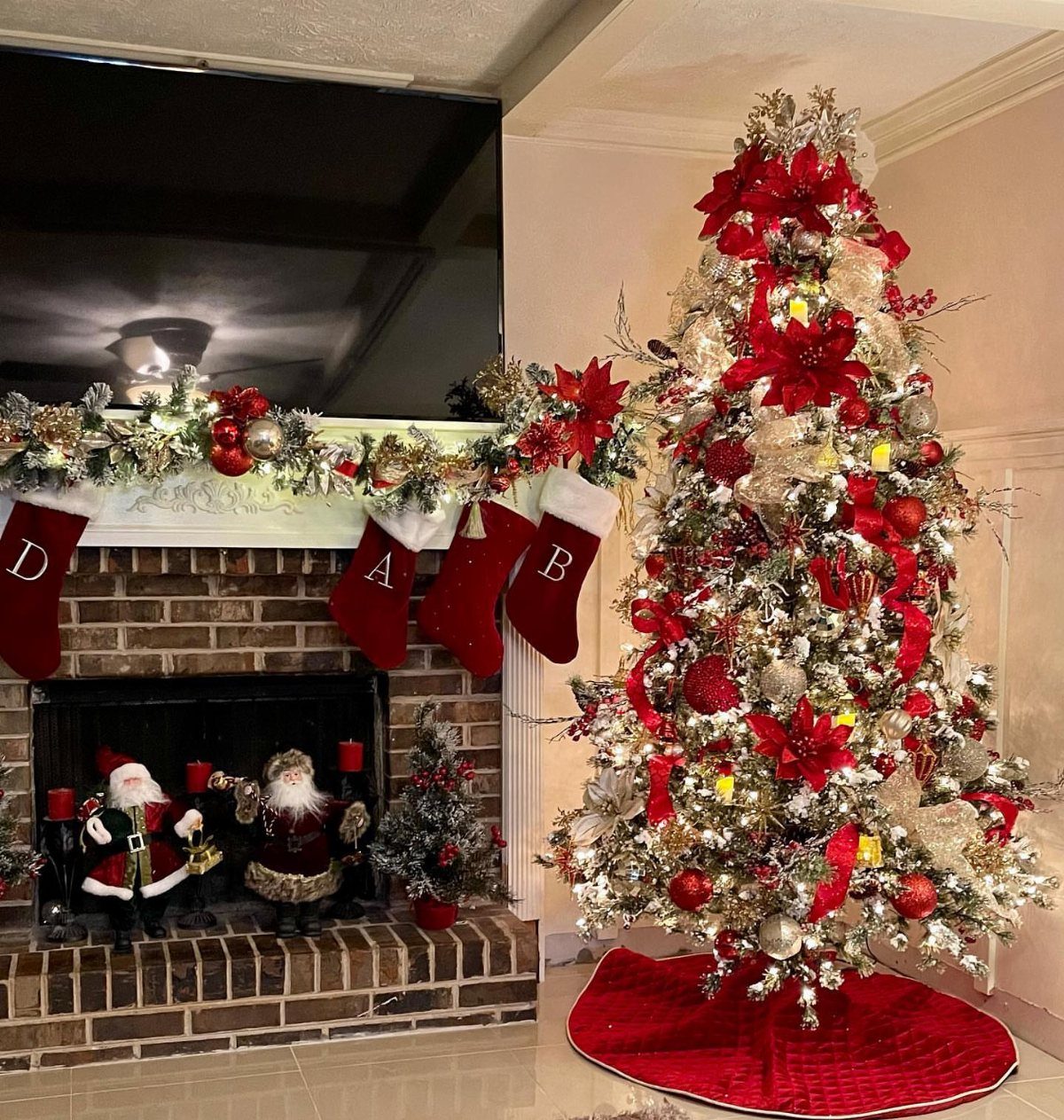 8 Christmas Tree Red and White Gold Decor Ideas for Holiday Elegance 2 Decorated Christmas tree with red poinsettias, gold branches, and red ornaments next to a brick fireplace.