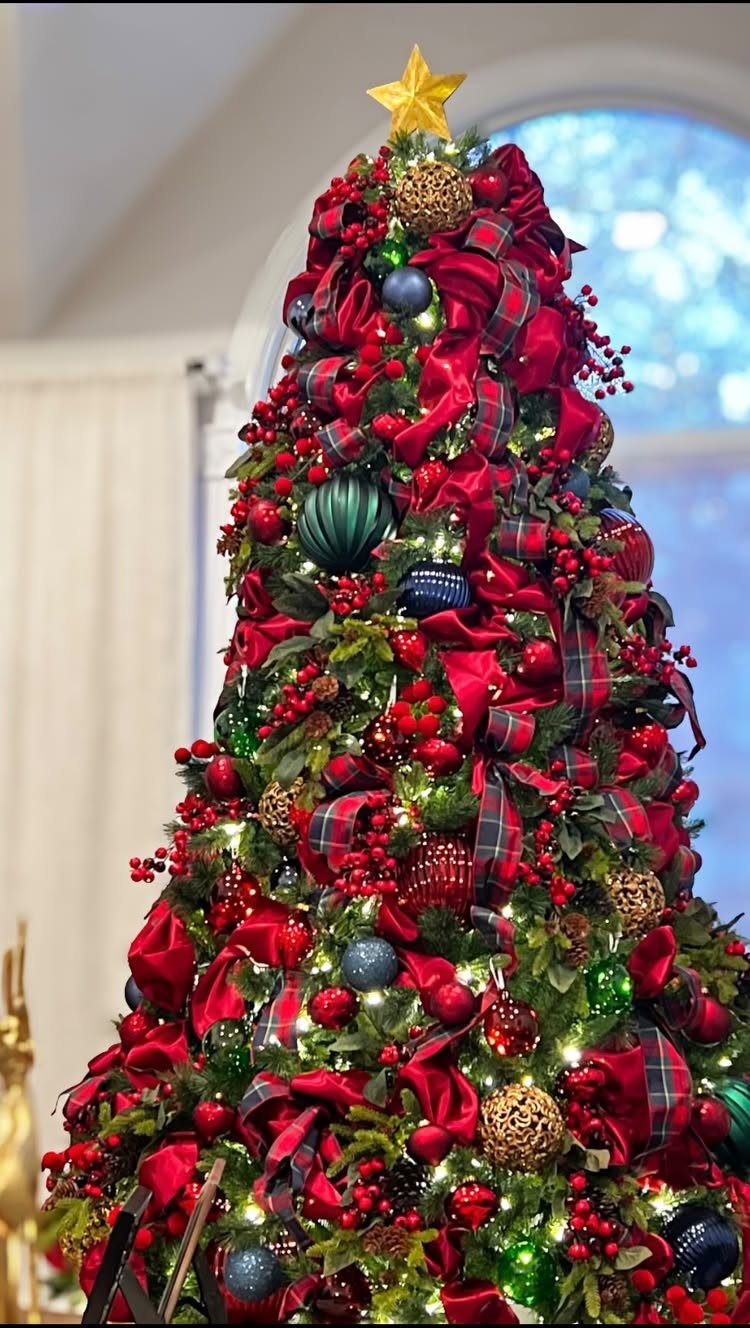 Christmas Tree Ribbon: 18 Styling Ideas That Work 15 A lushly decorated Christmas tree with red ribbons, berries, and colorful ornaments under a gold star.