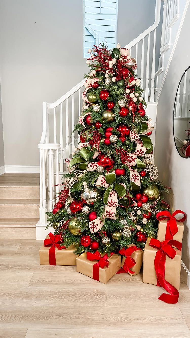 Christmas Tree Ribbon: 18 Styling Ideas That Work 5 Decorated Christmas tree with red ornaments and green velvet ribbon bows next to a staircase.