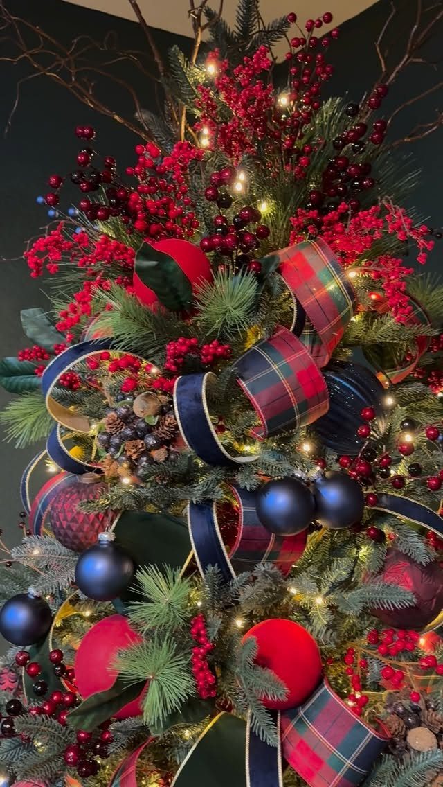 Christmas Tree Ribbon: 18 Styling Ideas That Work 8 Decorated Christmas tree with red berries, blue ornaments, and plaid patterned ribbons.