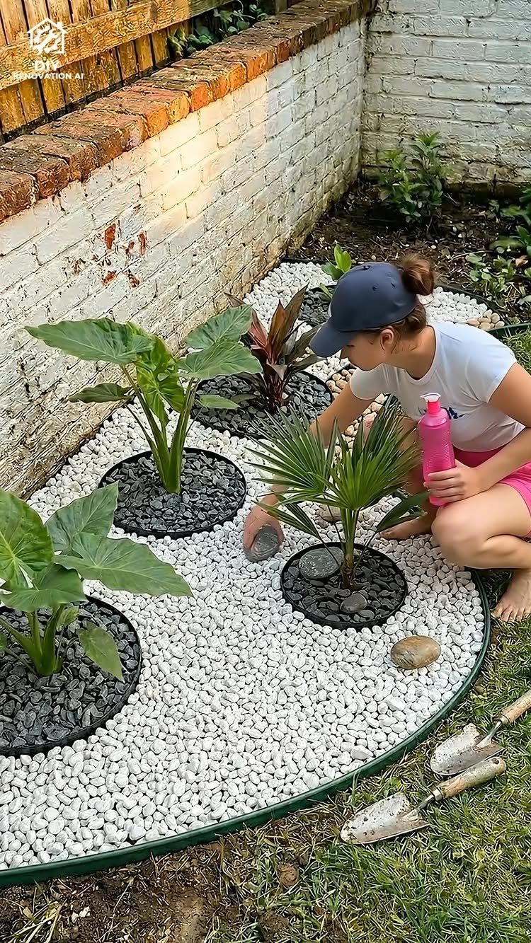20 Corner Yard Garden Ideas for Any Size Space 16 A person planting green plants into a garden bed filled with white and dark pebbles.