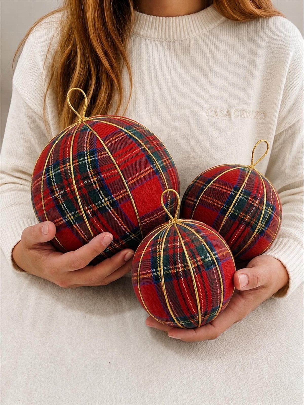Cricut Christmas Balls: 14 DIY Ornaments for 2026 2 Three red and green plaid flannel Christmas ornaments held in a person's hands.