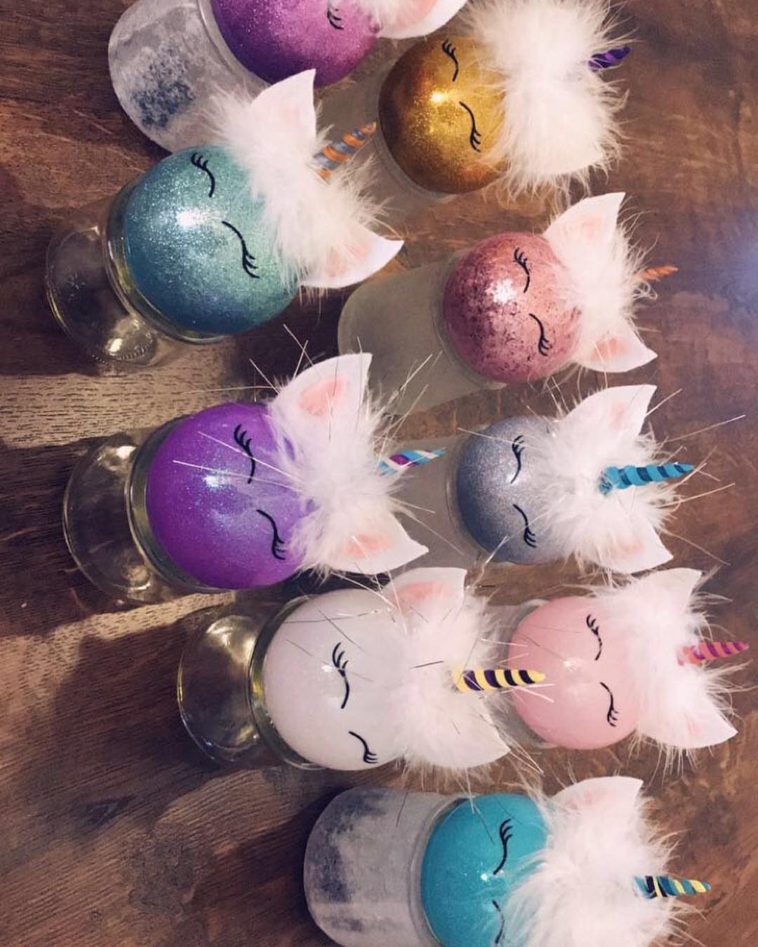 Cricut Christmas Balls: 14 DIY Ornaments for 2026 4 Glittery unicorn-themed glass ornaments with white faux fur and colorful striped horns on wood.