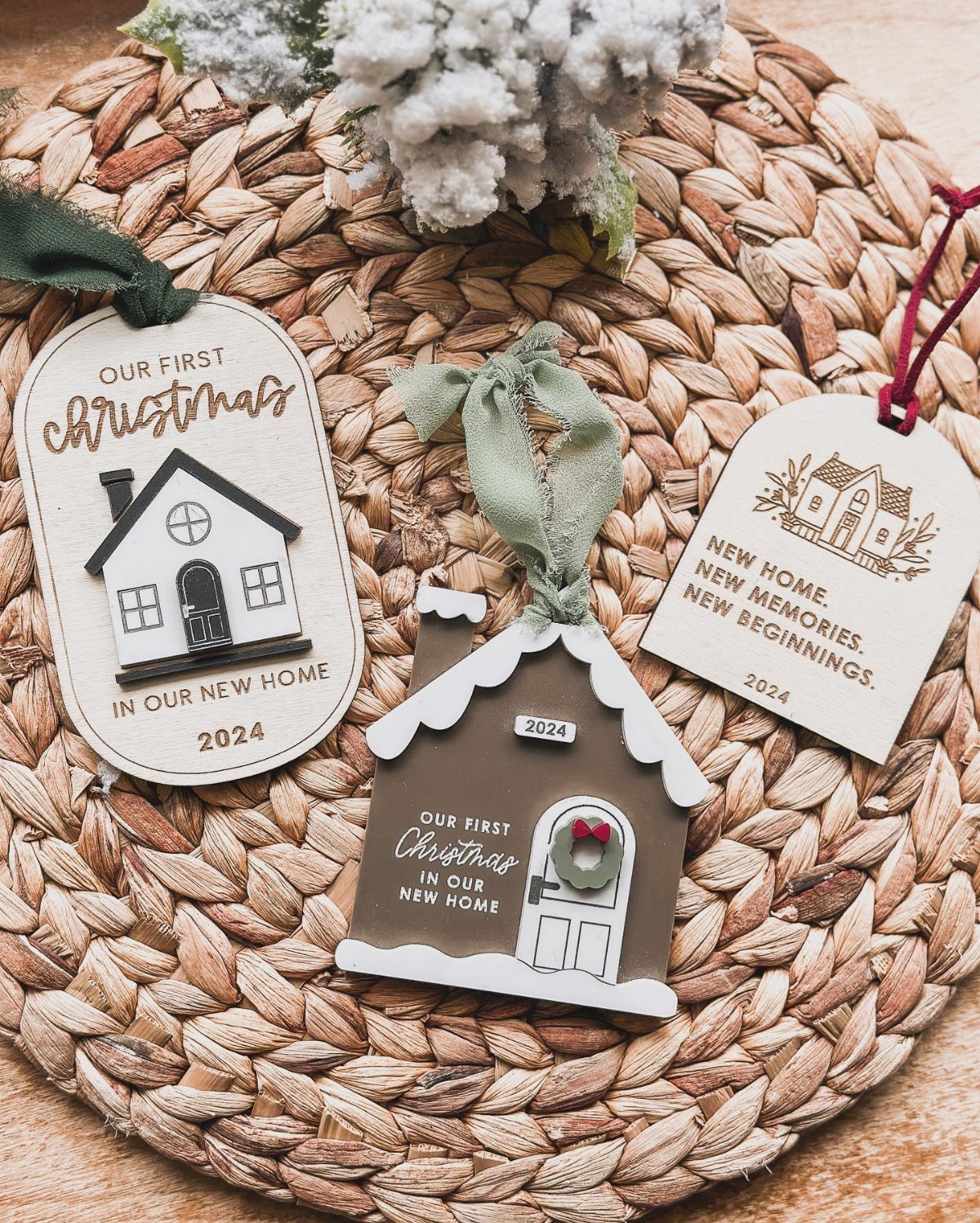 Cricut Christmas Balls: 14 DIY Ornaments for 2026 6 Three house-shaped Christmas ornaments with printed text resting on a circular woven straw mat.