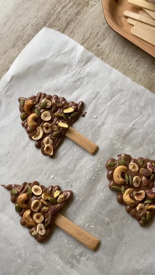 27 DIY Cheap Christmas Gifts for 2026 27 Three chocolate nut treats shaped like Christmas trees on white parchment paper.