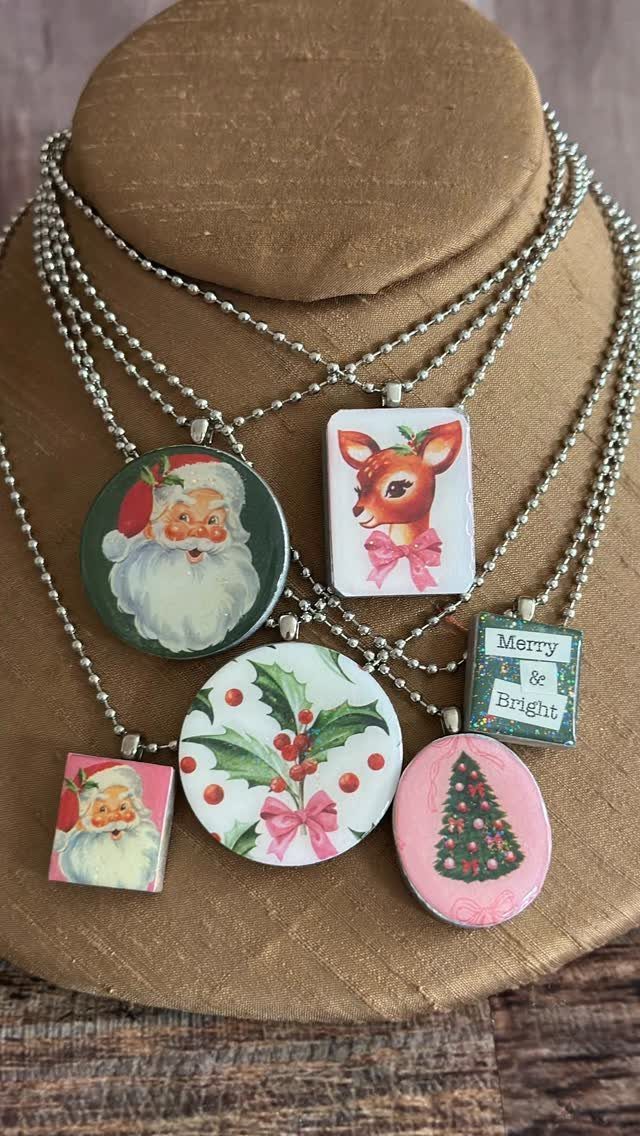 27 DIY Cheap Christmas Gifts for 2026 22 Silver bead necklaces with festive Christmas pendants displayed on a tan jewelry bust.