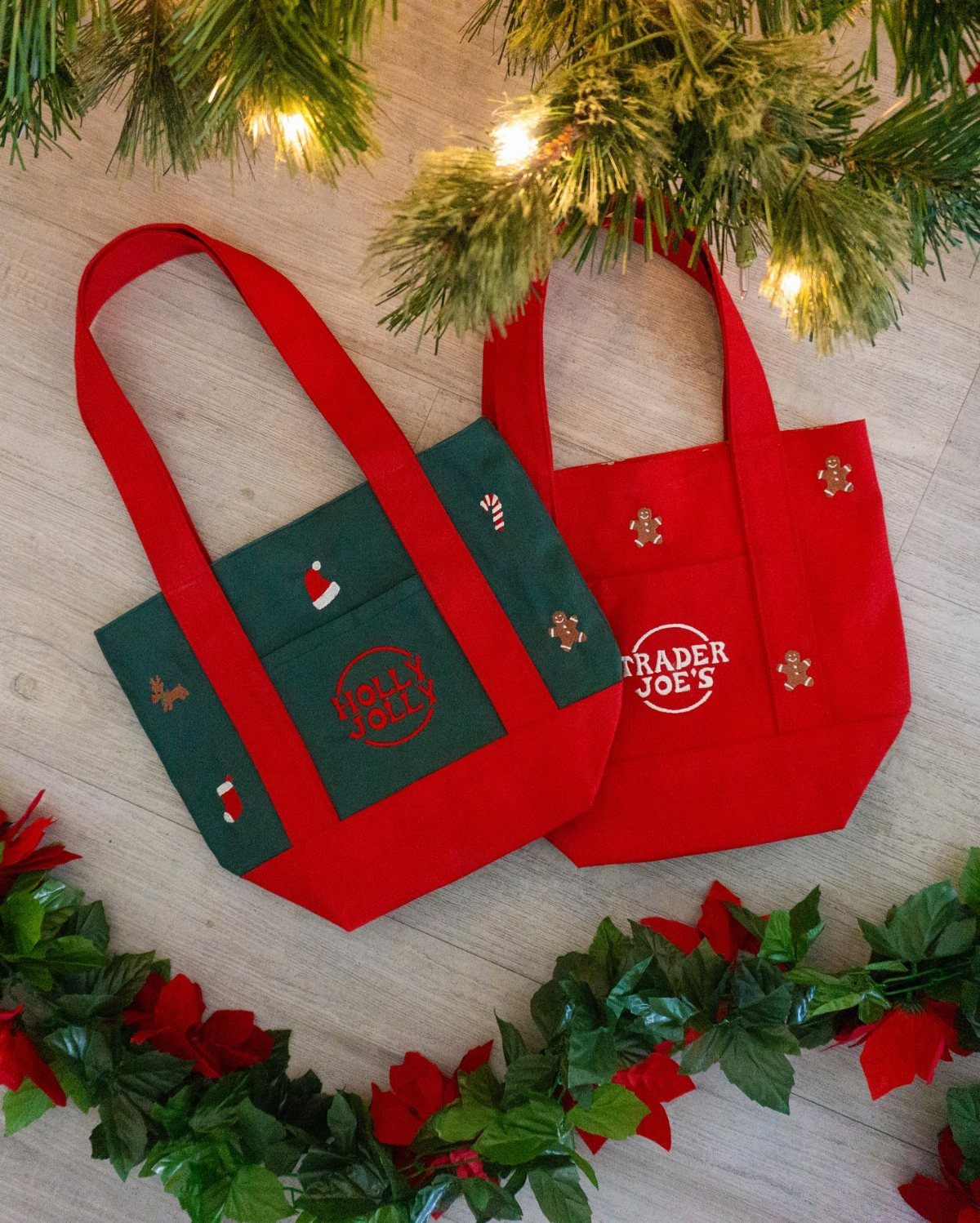 27 DIY Cheap Christmas Gifts for 2026 6 Two small red and green fabric tote bags resting on a wooden surface with pine branches.