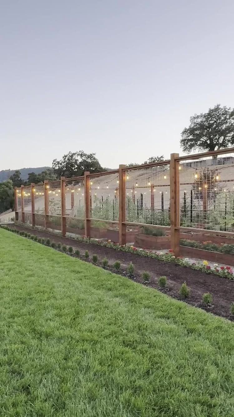 15 Huge Garden Design Ideas for Birds, Light, Night Paths and Still Water 15 Wooden garden trellis with glowing string lights overlooking a manicured lawn and garden beds.