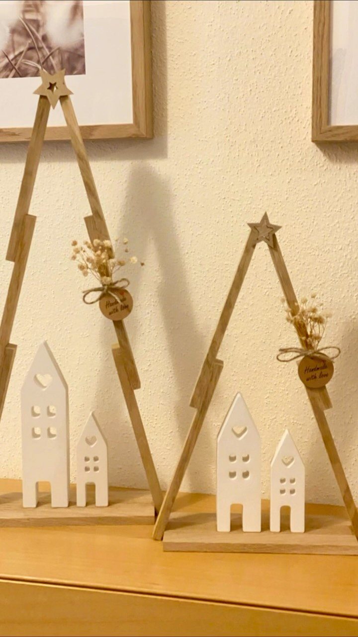 Make Wooden Christmas Trees: 7 DIY Projects from Scrap to Yard 4 Two small wooden triangular Christmas tree decorations with dried flowers and white miniature houses.
