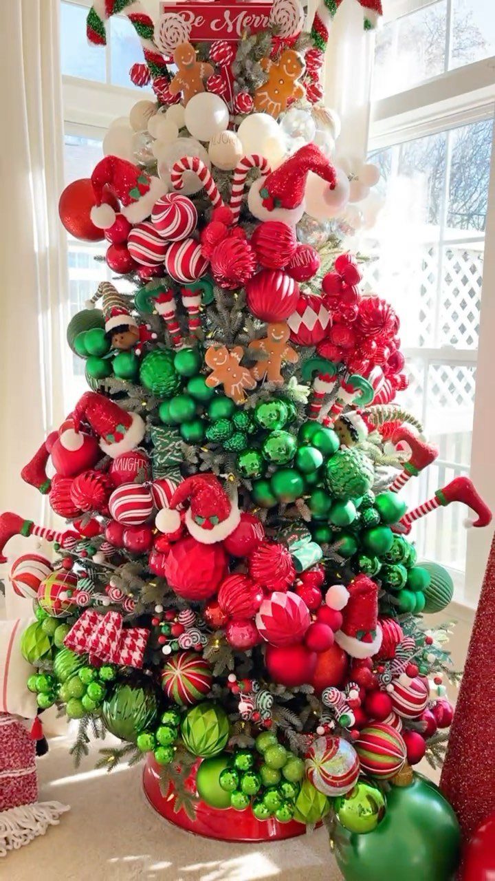 21 Most Beautiful Christmas Trees for Bold and Cozy Looks 10 A Christmas tree heavily decorated with red and green ornaments and candy canes.