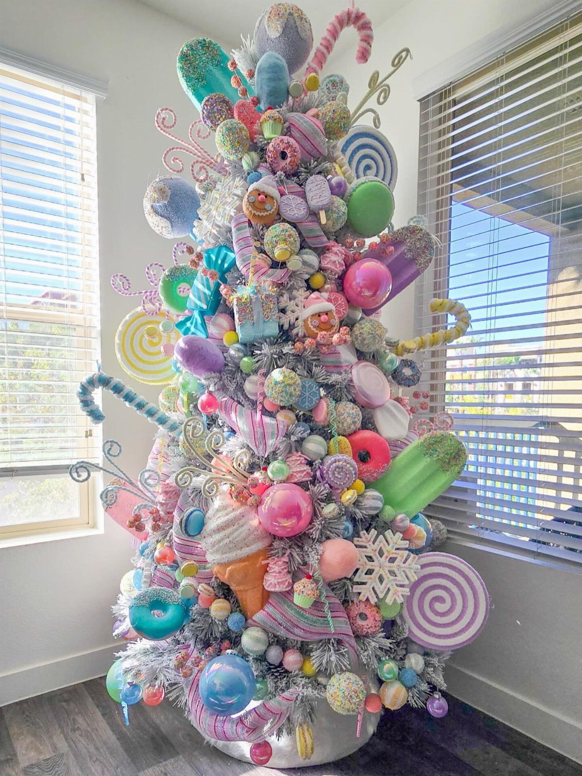 21 Most Beautiful Christmas Trees for Bold and Cozy Looks 4 A maximalist Christmas tree decorated with oversized pastel candy ornaments and colorful baubles.