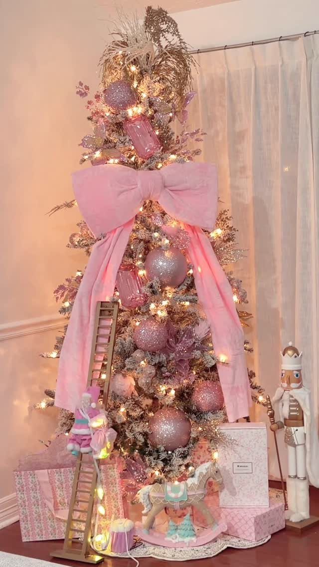 21 Most Beautiful Christmas Trees for Bold and Cozy Looks 2 A pink decorated Christmas tree with a large bow and warm glowing lights.