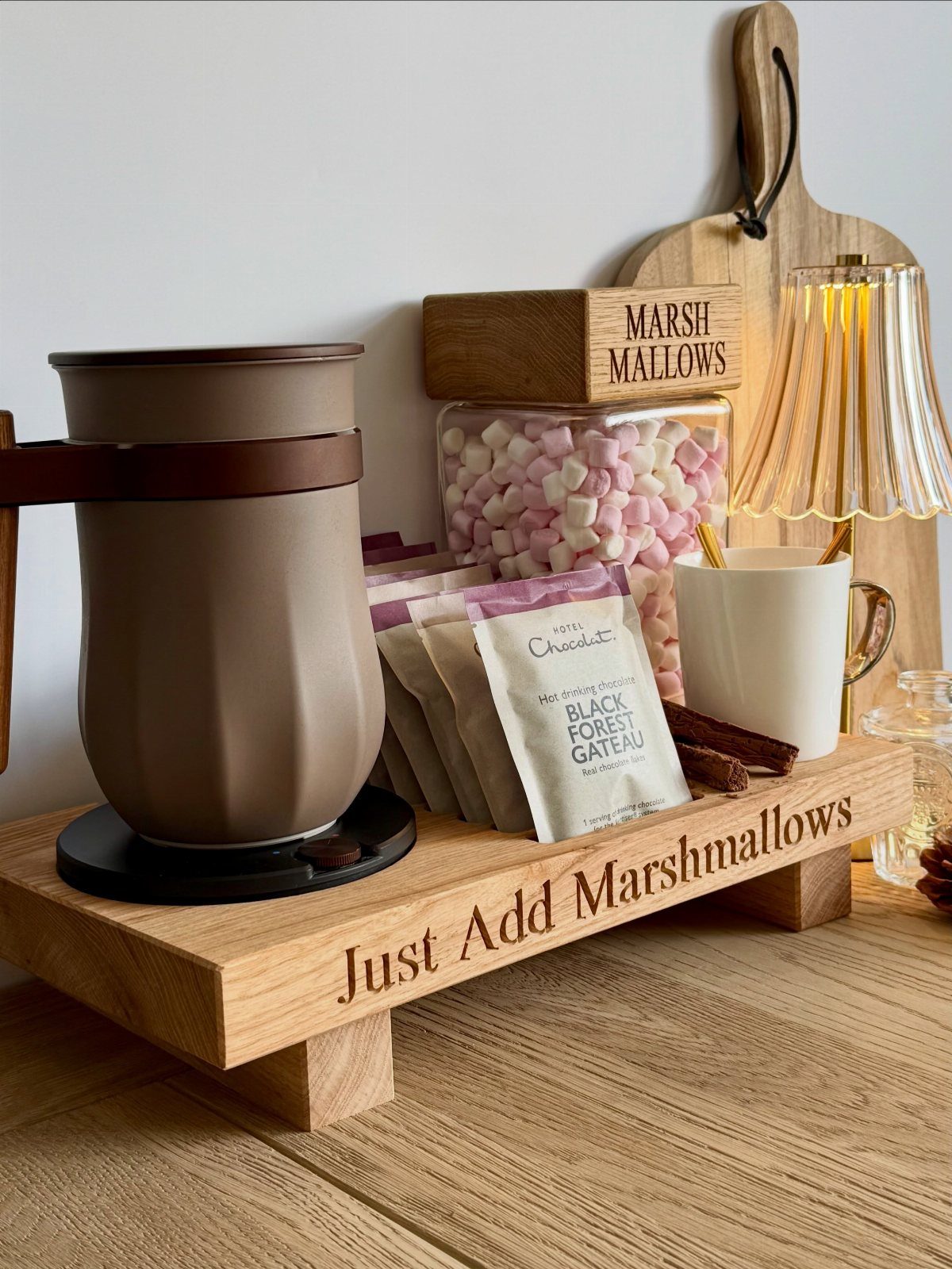 21 Things to Do for Christmas 2026 8 A hot chocolate station with marshmallows, cocoa packets, and a ceramic pot on a wooden tray.